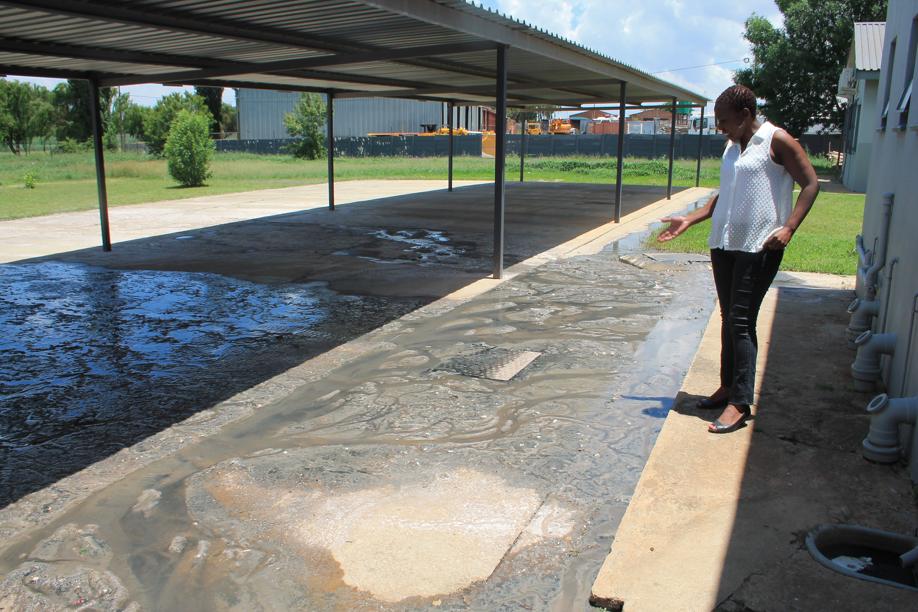 Ms Anna Ditkotsi at some of the sewage leaking out bhind the training centre.