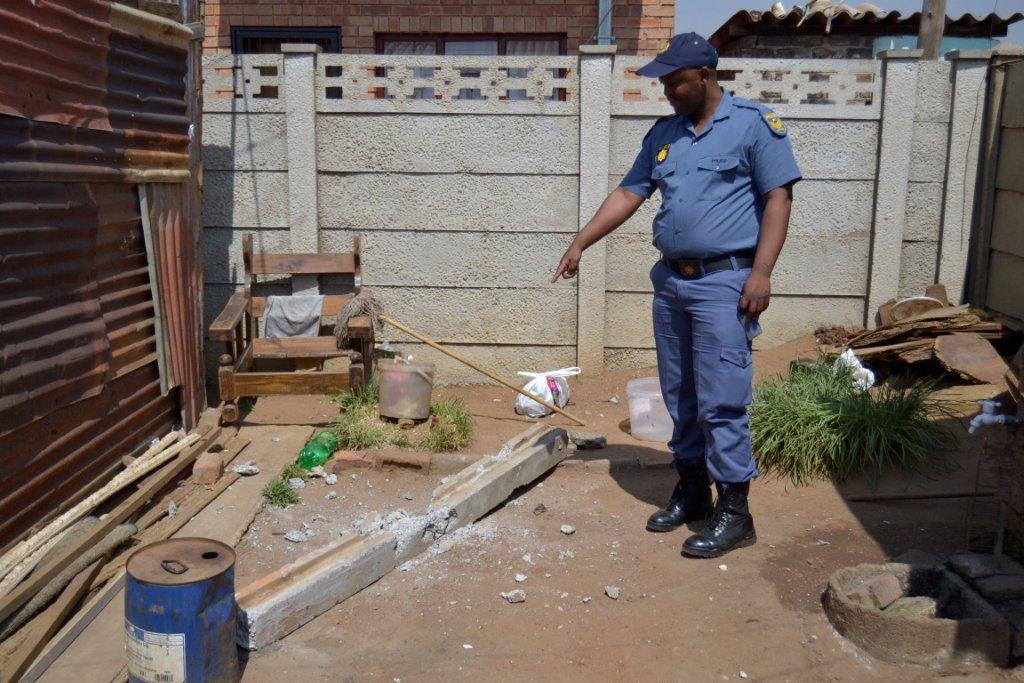 Police officer points out the damage done by a 'hammer gang' recently.