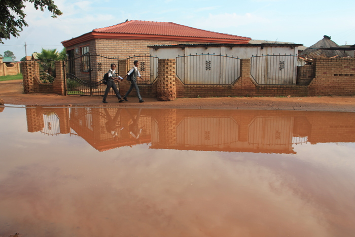 The flooded street in front of Tswasongu Secondary School. Insert: Members of Tswasongu Secondary School’s governing body in front of the disused sports grounds
