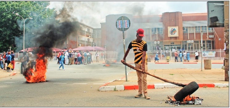 The street in front of the municipal building was chaos as protesters continued to burn tyres.