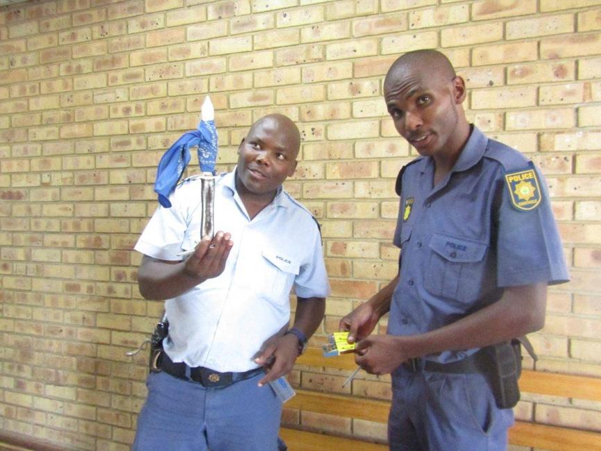 Constable Lucky Mokoena hoding the knife and Constable itumeleng Segopolo with the dagga