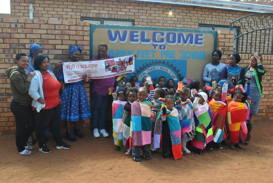 The Happy Feetstaff and the children with the donated blankets