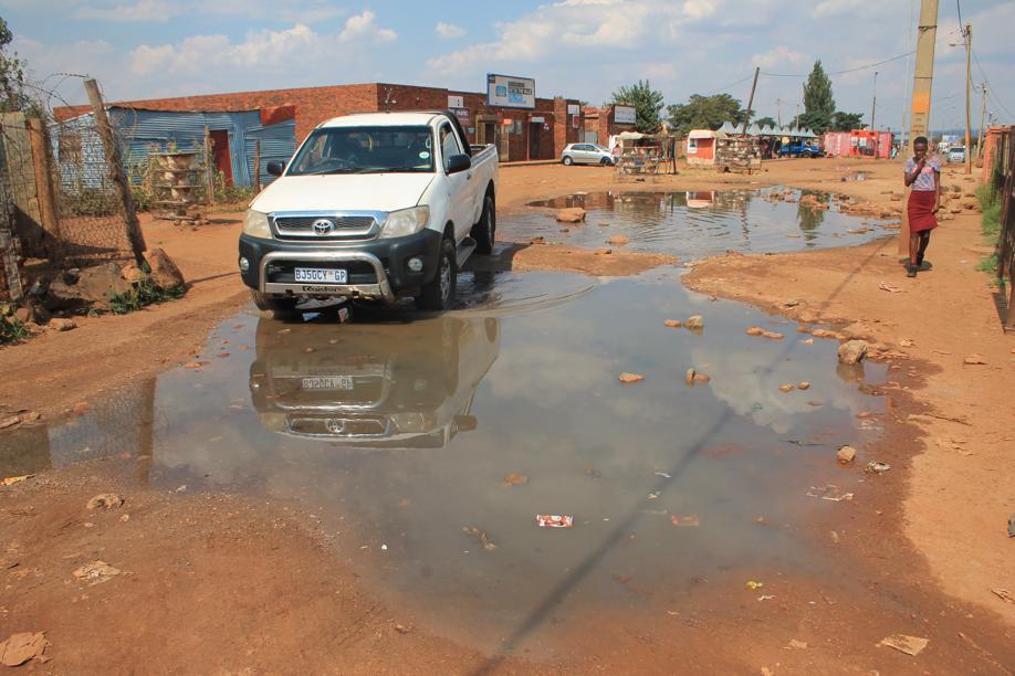A driver making his way through one of the leaks near the Xhosa Section taxi rank.