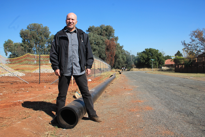Mr Carlos Rebelo straddles one of the PVC pipes in Bluebell Street.