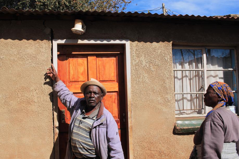 Mr Johnny Lolo shows a deep crack that had recently developed right next to the door of his house.