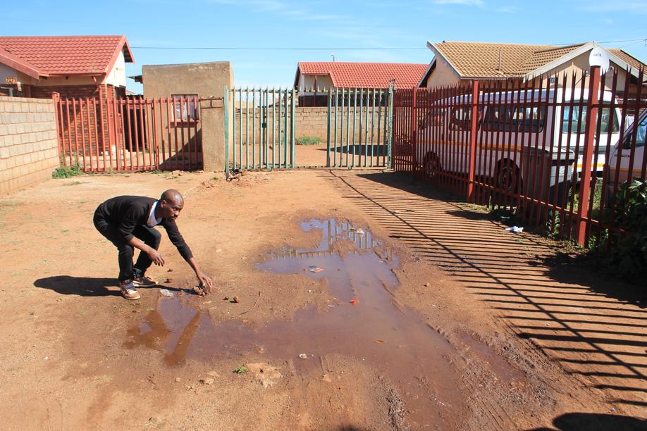 Mr Tsholo Mosikare shows the water leak at house no. 7270.