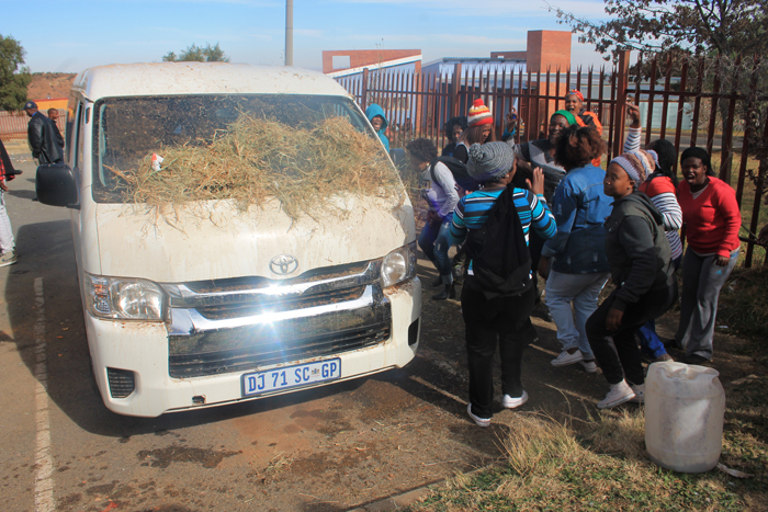 Youths toyi-toying outside the minibus in which the municipal workers were held hostage.