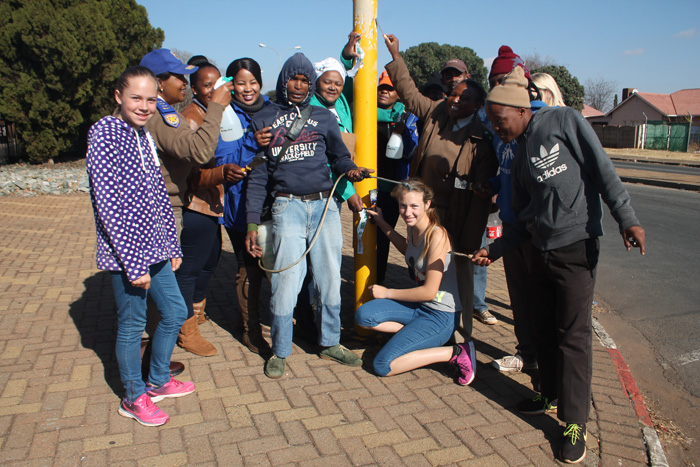 Municipal traffic officers and some of the other people who took part in the action removing posters from a traffic sign near KFC.