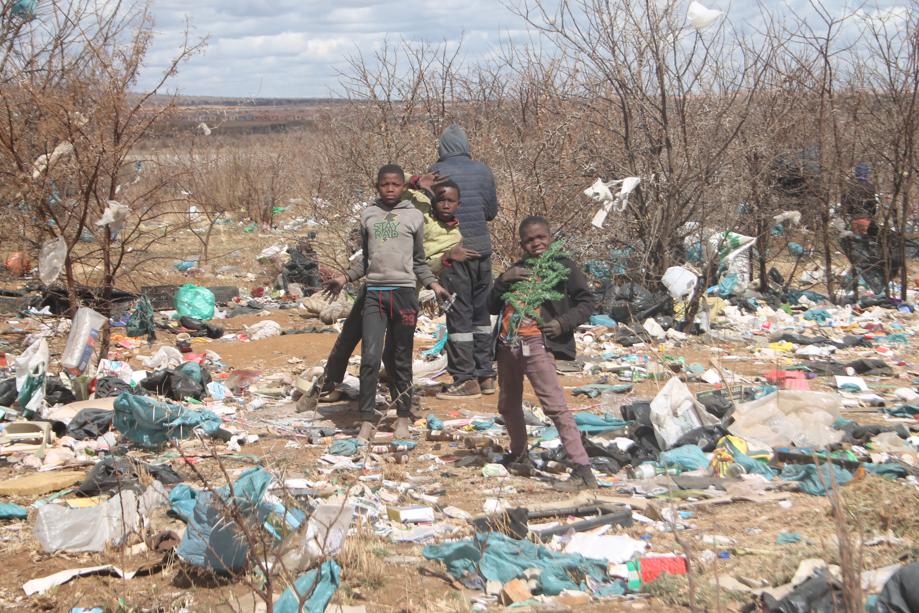 Some children playing among the rubbish in the veld next to the transfer station.