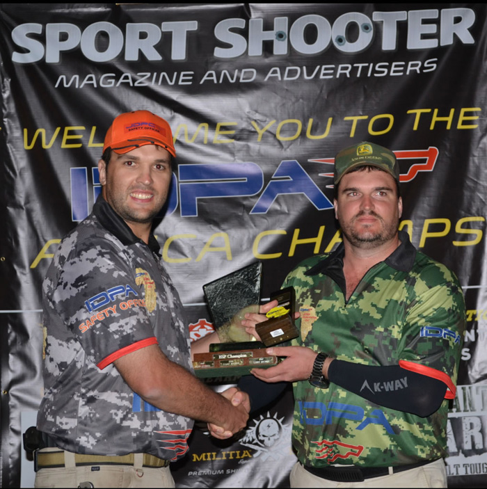Meyer du Plessis (regs) ontvang sy trofee as wenner van Danie van Huyssteen, 'n direkteur van SADPA South African Defensive Pistol Association (SADPA).