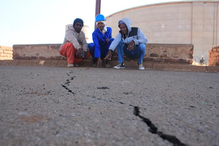 Residents showing some of the cracks in the tar at the taxi rank.