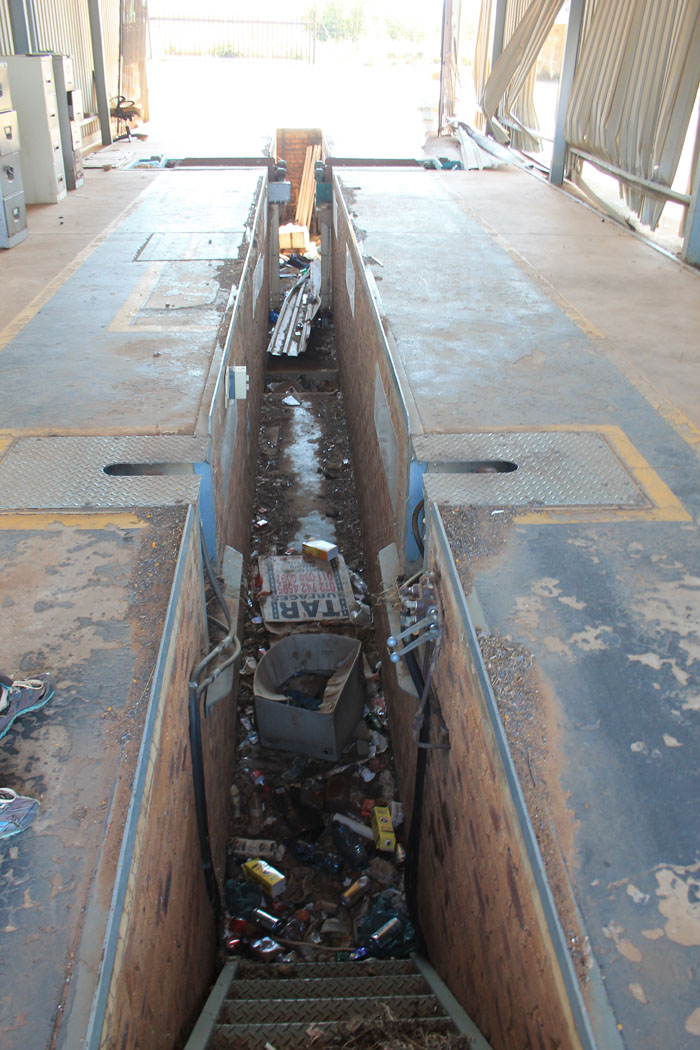 The vehicle testing bay is strewn with with rubbish.