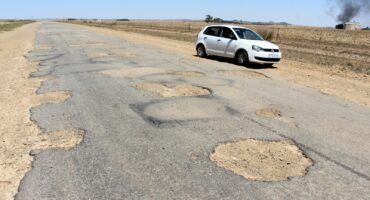The section of Station Road near the R54 is still in such a bad state that motorists have to drive on the side of the road.