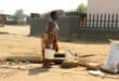 Many residents in Kokosi still have no water, which has forced people such as this woman to get water from a manhole on the sidewalk at Extension 1 near the ZCC Church.