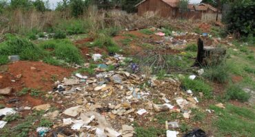 The veld near the corner is strewn with building rubble.