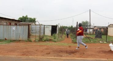 A community member walks past the passage where the latest killing took place on Monday.