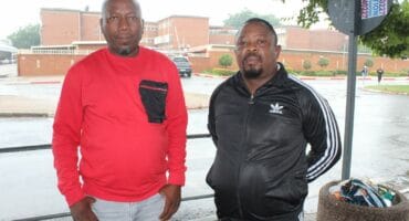 Members of the new NGO LMS, Motseki Kgotsana and Happy Lefakane, across from the Merafong City Local Municipality, which they say could easily have paid Eskom and Rand Water if they had settled the ongoing payment dispute with the mines.