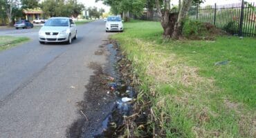Water leaking down Reinecke Street behind Carleton Jones High School.