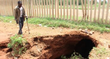 A concerned resident, Steven Ntulwa, checks out the growing sinkhole.