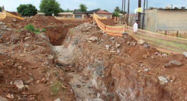 The huge unattended open trench near the old Teachers' Quarters, where a sinkhole caved in last night.