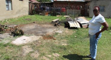 A friend of the family, Kate Misapiso, shows the remains of the shack where the little girl died.