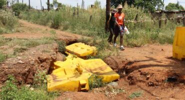 Residents have no choice but to walk on the edges of sinkholes just to get to and from their homes.