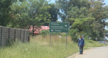 A pedestrian walks past the sign to the Oberholzer station where the shooting took place.