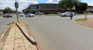 The pole of a broken street light laying at the corner of Anna Road and Gold Street.