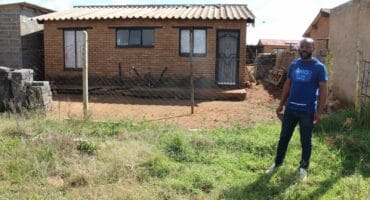 Buti Elliot Mtembu of OMO in front of one of several houses with asbestos roofs in Skopas in Khutsong. Photo: Adele Louw (Carletonville and Fochville Herald)