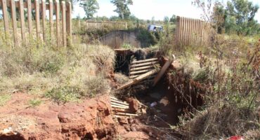 The fence separating the canal from Khutsong South has started to collapse into the sinkhole. Photo: Adele Louw (Carletonville and Fochville Herald)