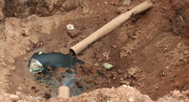 Sewage leaking into the sinkhole from the broken pipe that a municipal contractor tried to bury last month. Photo: Adele Louw (Carletonville and Fochville Herald)