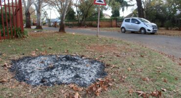 Residents of Lobelia Street rake the leaves from municipal trees into heaps on sidewalks and set them alight. Photo: Adele Louw (Carletonville and Fochville Herald)