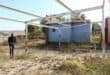 A concerned resident, Ayanda Tobo, walks through the skeleton of what used to be the car wash. Photo: Adele Louw (Carletonville and Fochville Herald)