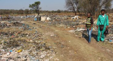 Concerned residents Lunga Situta and Thabiso Mafusini at the massive rubbish dump that recently started just outside Wedela. Photo: Adele Louw (Carletonville and Fochville Herald)