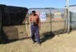 A supervisor at the project, Daniel Nokwane, in front of the yard with unused pieces of clear-view fencing that is not being used while the project is stalling. Photo: Adele Louw (Carletonville and Fochville Herald)