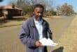 Mzwandile Kheswa, with proof of the alleged bribery, is standing in Geldenhuys Street near where the problems occurred. Photo: Adele Louw (Carletonville and Fochville Herald)