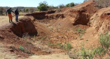 Concerned residents, Lunga Zituta and Mike Mohoza, at the massive hole behind Wedela Ext 4. Photo: Carletonville and Fochville Herald