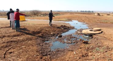 Community members gathered at the site of the sinking manhole on Monday morning. Photo: Adele Louw (Carletonville and Fochville Herald)