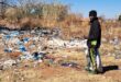 A resident looks at one of the rubbish heaps on the outskirts of Fochville.