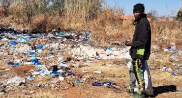 A resident looks at one of the rubbish heaps on the outskirts of Fochville.