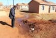 Mzwandile Kheswa of the Elderly Movement For Change pointed out various problems, such as a water leak at house no. 9163 in Ext 6. Photo: Adele Louw (Carletonville and Fochville Herald)