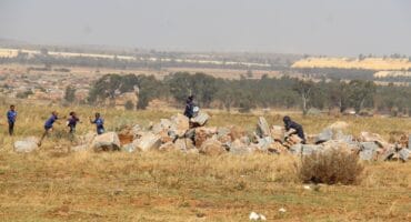 Learners playing on a heap of rocks taken out by a municipal contractor. Photo: Adele Louw (Carletonville and Fochville Herald)
