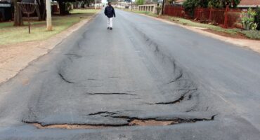 Some of the deep cracks in the newly tarred road in Station Street in Welverdiend.