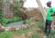 One of the helpers, Thabang Buchingi, shows how community members have dammed up the sewage at the leaking manhole. Photo: Adele Louw (Carletonville and Fochville Herald)