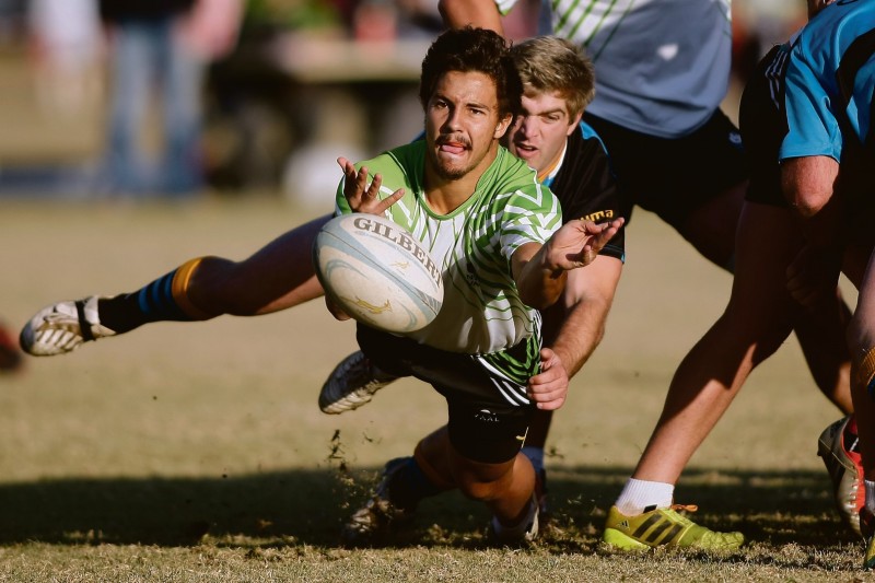 Jaco Coetzee, skrumskakel van die NWU Vaal se eerste rugbyspan, laat loop die bal aan sy skakelmaat terwyl sy regstreekse teenstander op hom toesak. Foto’s: Ettienne van Rensburg