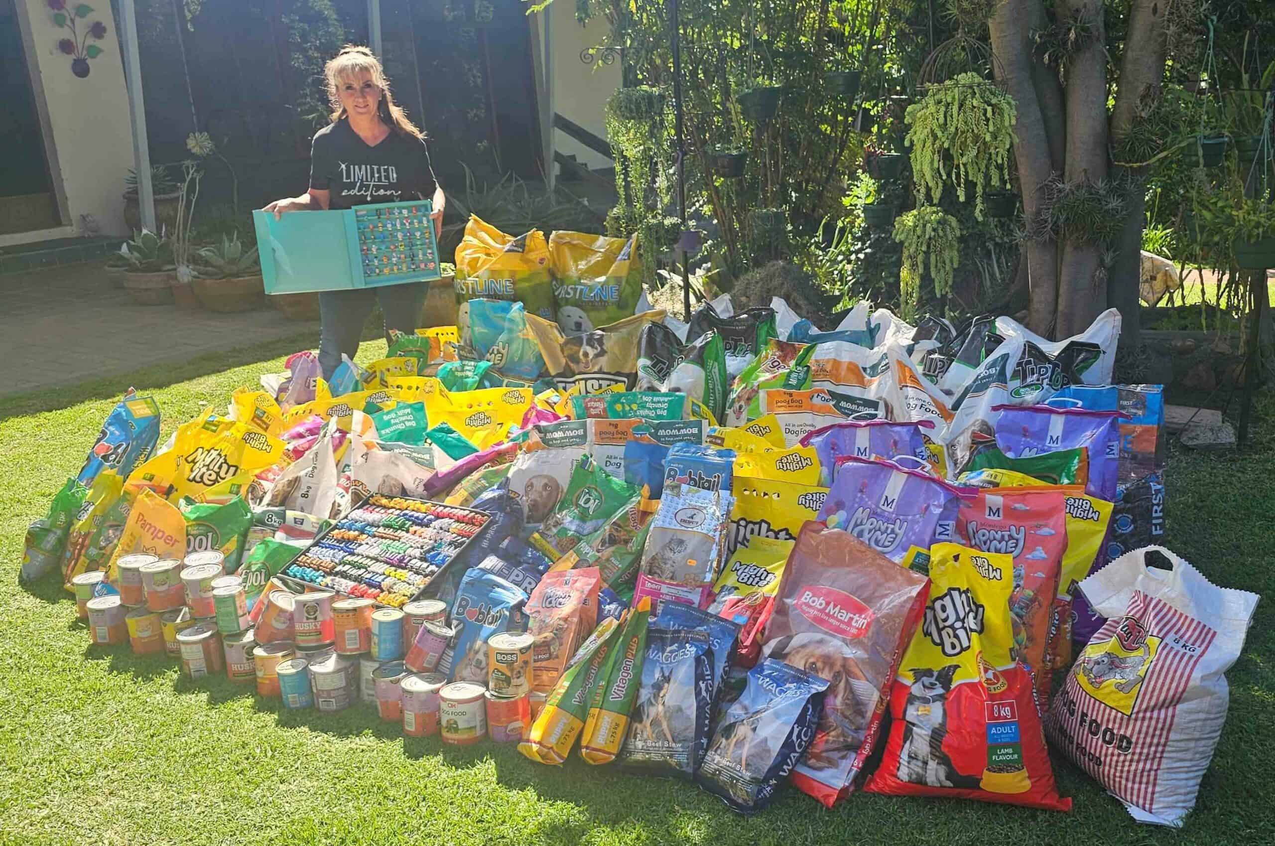 Liezel Hagar met die 1 050kg se honde- en katkos wat sy met haar mini-projek ingesamel het vir organisasies wat omsien na diere in nood.
