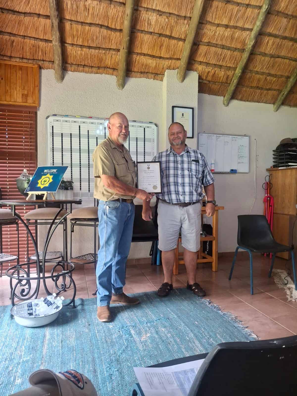 Pieter Kemp oorhandig die medalje en sertifikaat namens Landelike Gemeenskap Veiligheid (LGV) aan Peet Swanepoel.