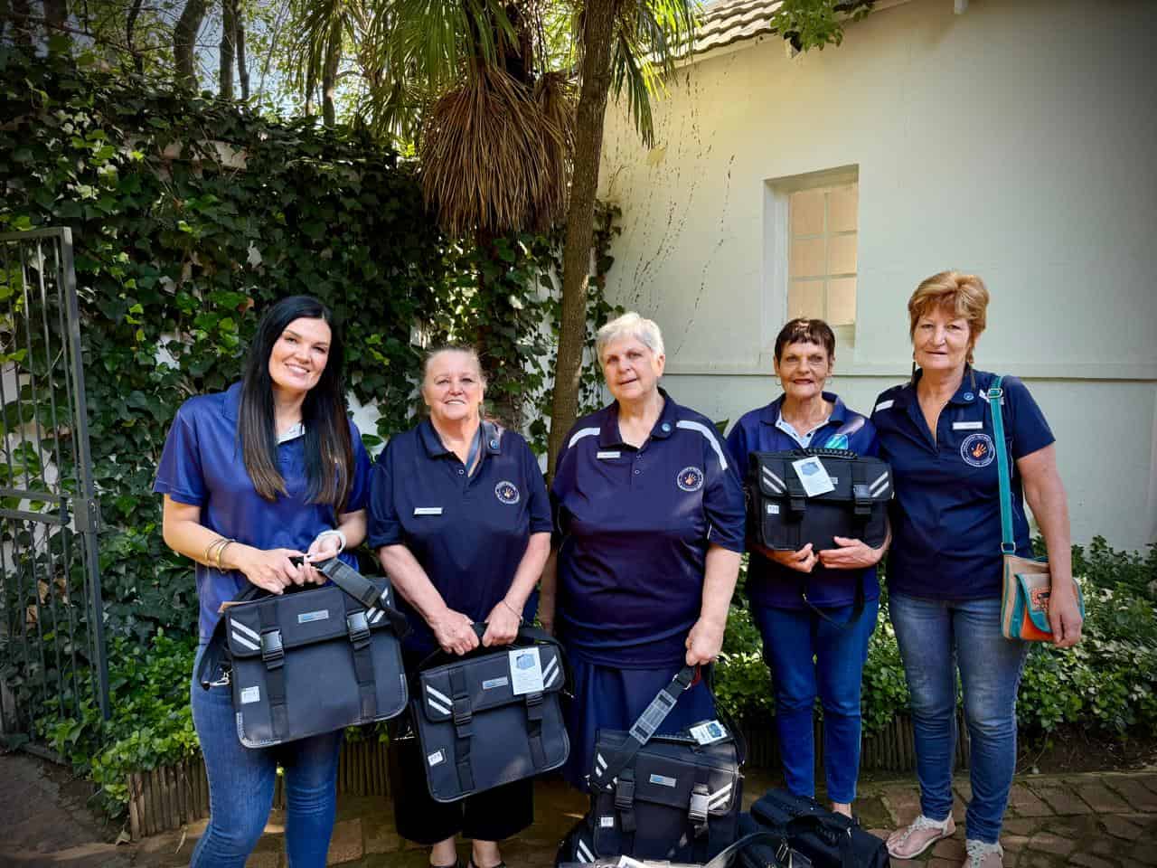 Solidariteit Helpende Hand verteenwoordigers met van die skooltassies wat by Parys Christelike Skool (PCS) oorhandig is. Foto: Verskaf