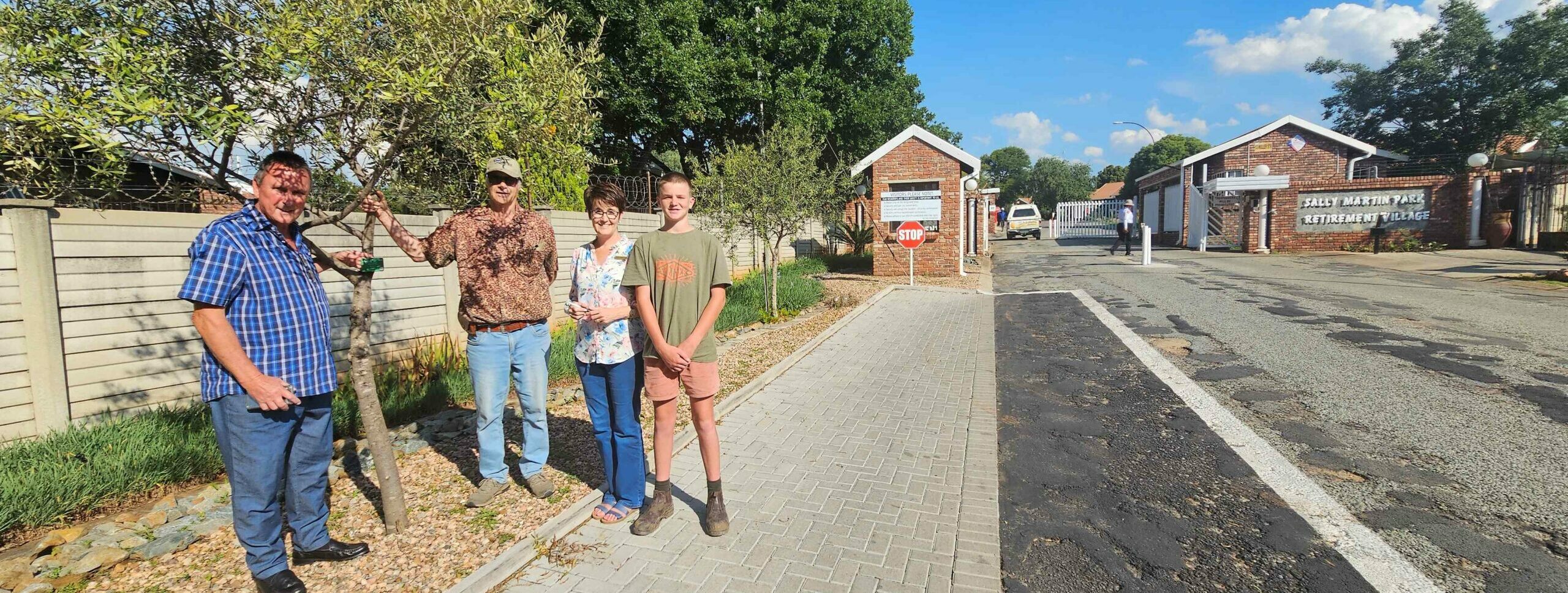 Van links is Dr. Abé Kempen (Voorsitter: Lewensreg Inwonerskomitee), Flip du Plessis (boomkenner en self ook 'n inwoner van Sally Martin Park), Elchristie Oberholzer (Bestuurder: Sally Martin Park) en Seeff Dannhauser Jr, by 'n olienhoutboom wat gemerk is.