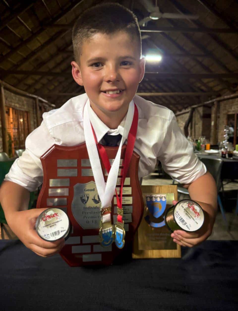 'n Trotse Hay-din Oelofse met die medaljes, toekenning en skild wat hy ontvang het.